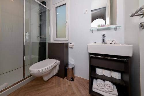 een badkamer met een toilet, een wastafel en een douche bij MORENIA Park Villas in Podaca