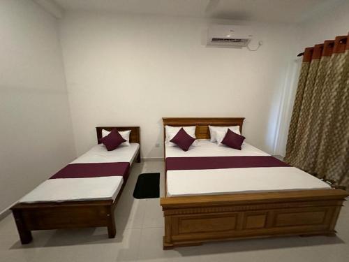two twin beds in a room at highway reach Layathraa in Kaduwela