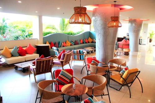a lobby with chairs and couches and tables at Mercure Bali Nusa Dua in Nusa Dua