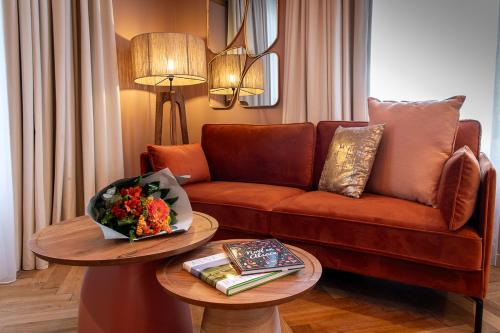 a living room with a couch and two tables at Hôtel Restaurant Vaillant proche Europapark Rulantica in Sélestat