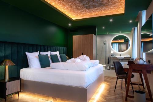 a bedroom with a white bed with a green wall at Hôtel Restaurant Vaillant proche Europapark Rulantica in Sélestat