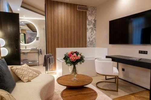 a living room with a vase of flowers on a table at Hôtel Restaurant Vaillant proche Europapark Rulantica in Sélestat