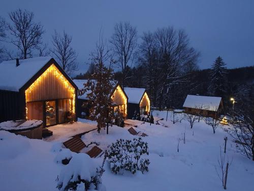 a couple of barns in the snow at night at Domandi mountain holiday lodges in Przesieka