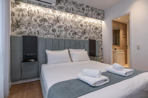 a bedroom with a large bed with towels on it at Kriel Suites by LIV Homes in Athens
