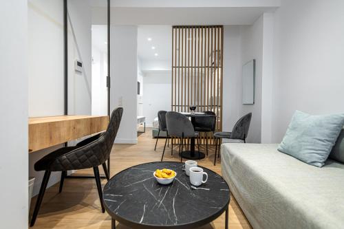 Kriel Suites by LIV Homes في أثينا: غرفة معيشة مع سرير وطاولة