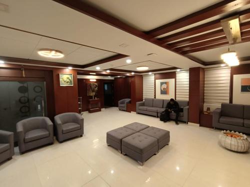 a lobby with a person sitting in a waiting room at Hotel Monsoon Palace Guwahati in Guwahati