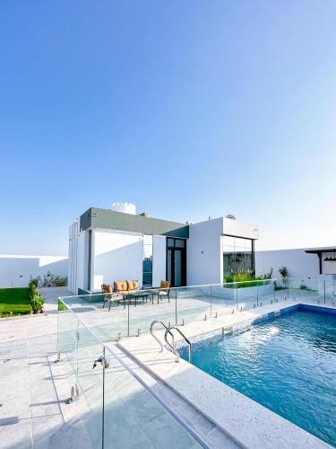 a villa with a swimming pool and a house at كرم شاليه in Barka