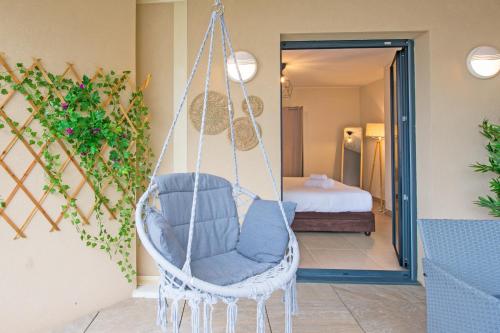 een schommelstoel in een kamer met een slaapkamer bij Vue Monaco & Tour Odéon, Terrasse, Parking Gratuit in Beausoleil