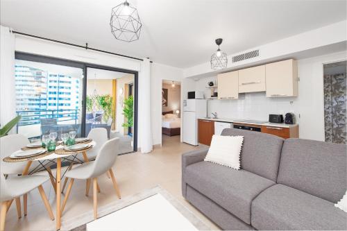 un salon et une cuisine avec un canapé et une table dans l'établissement Vue Monaco & Tour Odéon - Terrasse - Parking - BH, à Beausoleil