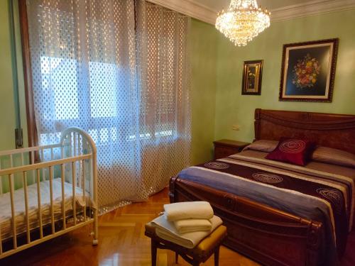 Rincón de Soto的住宿－LA RIOJA HOUSE casa entera Mesa de pinpong Parking gratuito, Chimenea, barbacoa CENTRO，一间卧室配有一张床、一张婴儿床和一扇窗户。