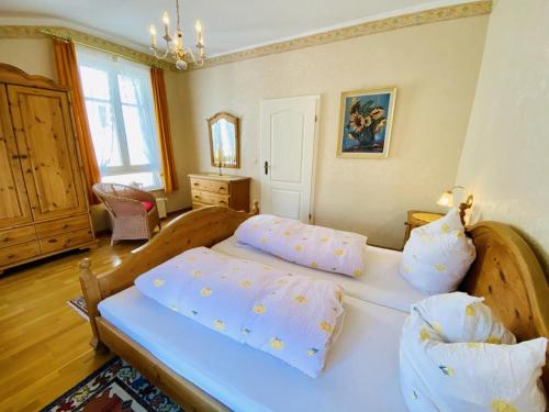 um quarto com uma cama grande com lençóis e almofadas azuis em Haus Louise/Schwalbennest em Warnemünde