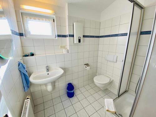 uma casa de banho com um WC, um lavatório e um chuveiro em Haus Louise/Schwalbennest em Warnemünde