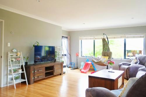 a living room with a couch and a tv at Rotorua 5 Bedrooms 3 bathroom family house in Rotorua