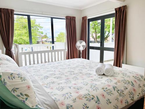 a bedroom with a bed with two towels on it at Wylie 5 Bedrooms house in Rotorua