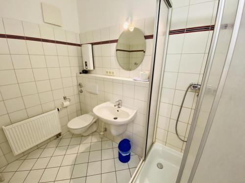 a bathroom with a toilet and a sink and a shower at Haus Louise/Sternenblick in Warnemünde