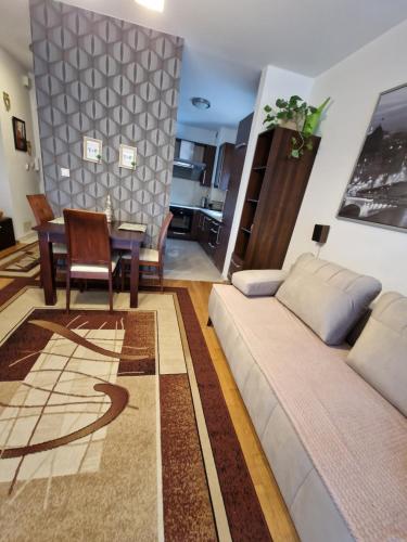 華沙的住宿－Kameralna Głębocka，客厅配有沙发和桌子