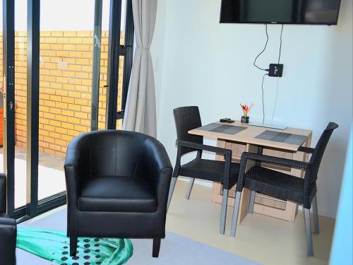 a dining room with a chair and a table at Dasha Accommodation Yzerfontein in Yzerfontein