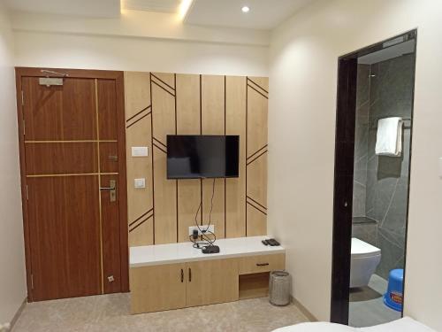 a bathroom with a tv on a wall at Hotel Suvarnam Residency in Ahmadnagar