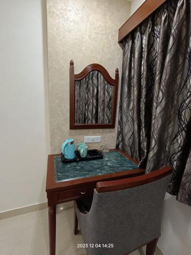 a small table with a mirror and a bed at Hotel Monsoon Palace Guwahati in Guwahati