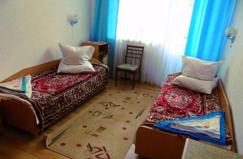 een kleine kamer met 2 bedden en een stoel bij Санаторій Збруч in Sataniv