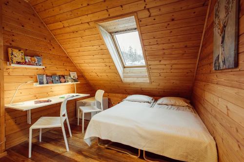 a bedroom in a wooden cabin with a bed and a desk at SZUMiPOTOK Szczyrk in Szczyrk