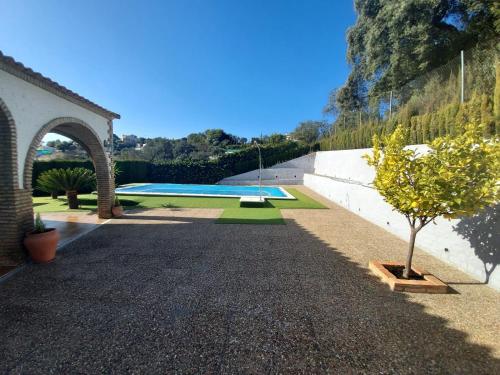 un jardin avec une piscine et un arbre dans l'établissement La encina, à Guillena