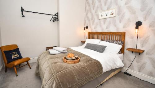 a bedroom with a bed and a chair at The Cranny 2 Bed House in Central Morpeth in Morpeth
