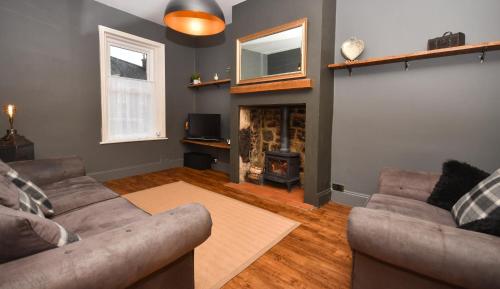 a living room with a couch and a fireplace at The Cranny 2 Bed House in Central Morpeth in Morpeth