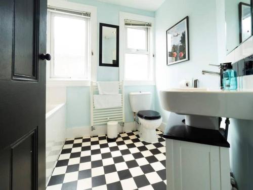 a bathroom with a black and white checkered floor at Warwick Weekender in Margate