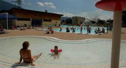 a couple of people in a swimming pool at Appartement T3 in Frontenex-Villard-Rosset