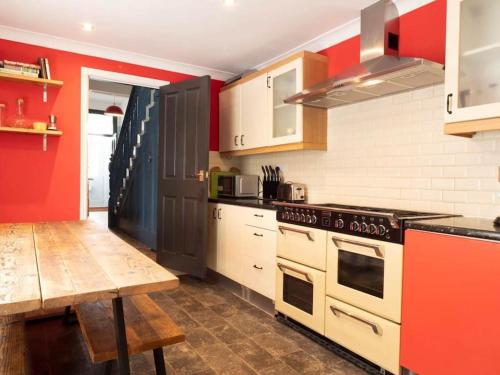 a kitchen with a stove and a wooden table at Warwick Weekender in Margate