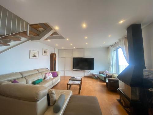 uma sala de estar com um sofá e uma televisão de ecrã plano em Agrovillaujue apartamentos rurales em Ujué