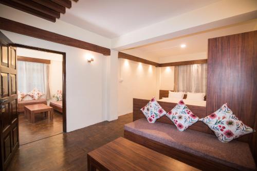 a living room with a couch with pillows on it at Madhuban Service Apt in Gangtok