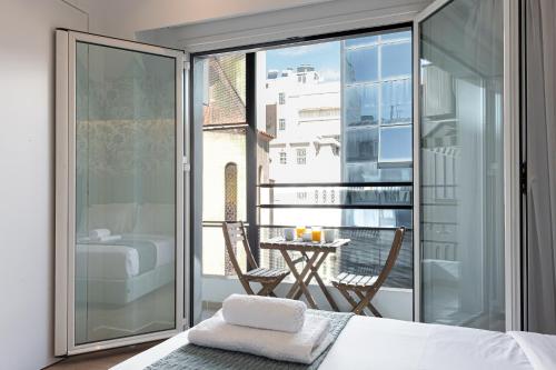 a bedroom with a balcony with a bed and a table at Kriel Suites by LIV Homes in Athens