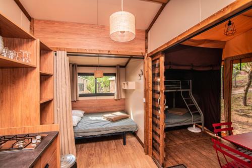 a tiny house with a bedroom and a bunk bed at Camping Onlycamp de Wasselonne in Wasselonne
