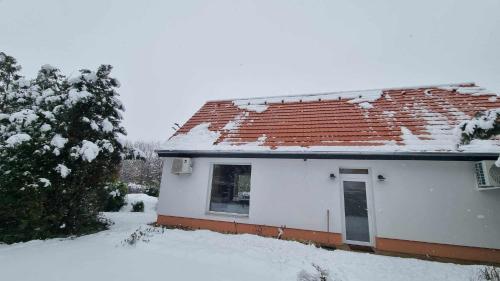 a white house with snow on the roof at Bella in Óhid