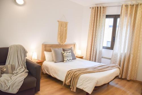 a bedroom with a bed and a chair and a window at La Neu I Studio Pas de Casa HUT2-8055 in Pas de la Casa