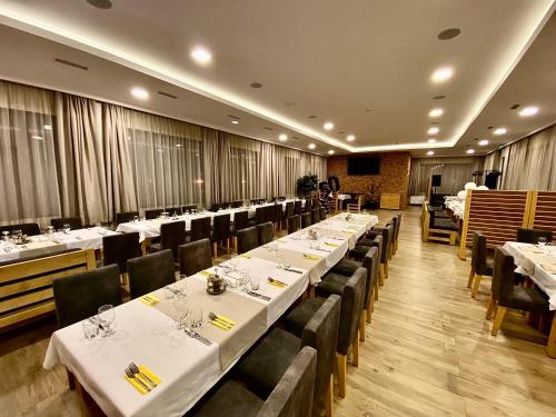 een rij tafels in een restaurant met witte tafelkleden bij Комплекс Дунав in Ruse