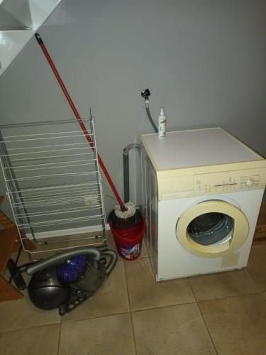 a washing machine with a mop next to a washer at de Paardekracht in Serooskerke