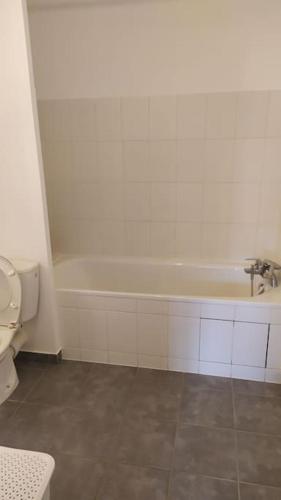 une salle de bain avec baignoire et toilettes dans l'établissement T2 de 42m² A proximité de la gare à 30min de PARIS, à Mantes-la-Jolie