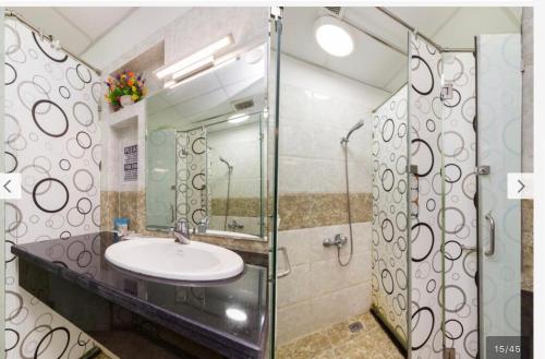 a bathroom with a sink and a glass shower at Mobylette Sai Gon in Ho Chi Minh City