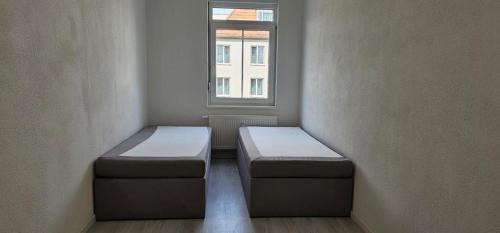 a room with two beds in front of a window at Timeless: 4 Zimmer Apartment OG Ludwigsburg in Ludwigsburg