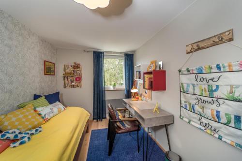 ein Schlafzimmer mit einem gelben Bett und einem Schreibtisch in der Unterkunft 2BR-Apartment in Herzogenaurach in Herzogenaurach