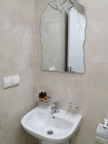 a bathroom with a sink and a mirror at فندق الشموخ Hotel Al Shmokh in Bir Gandouz