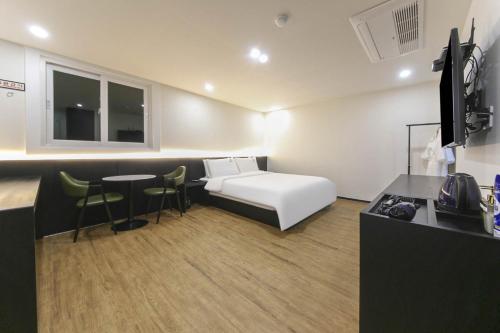 um quarto de hotel com uma cama e uma mesa em Busan Seomyeon Broa Hotel em Busan