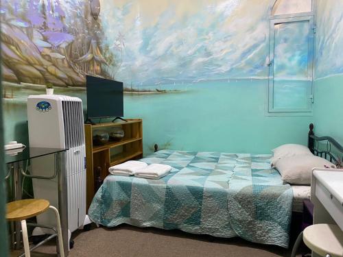 1 dormitorio con 1 cama y una pintura en la pared en Backpackers Place - Central Bus Terminal en Abu Dabi