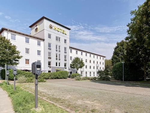 een wit gebouw met een bord aan de zijkant bij B&B Hotel Köln-West in Keulen