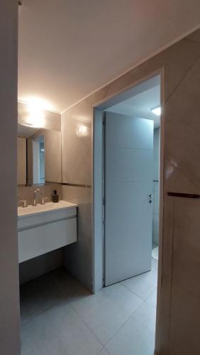 bagno con lavandino e porta scorrevole in vetro di Alojamiento Chacra El Monje a El Hoyo