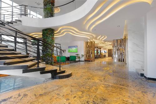 a lobby with a spiral staircase and a stair case at GTA HOTEL IKEJA in Ikeja