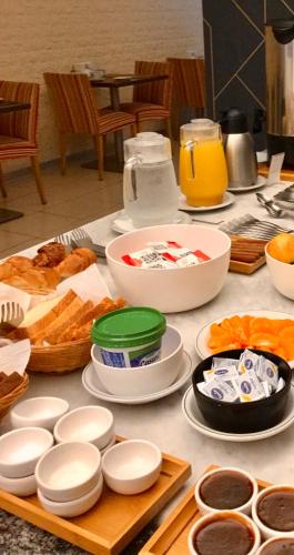 a table topped with plates and bowls of food at Apart Hotel Rio Grande in Rosario